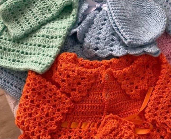 Crochet baby cardigans and bonnets in green, blue and orange